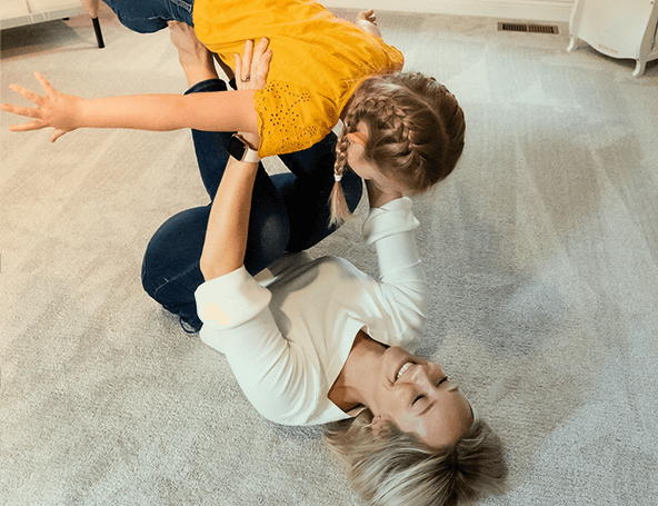 A mother playing with her child on clean carpet