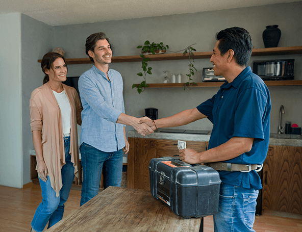 A couple shaking hands with a handyman