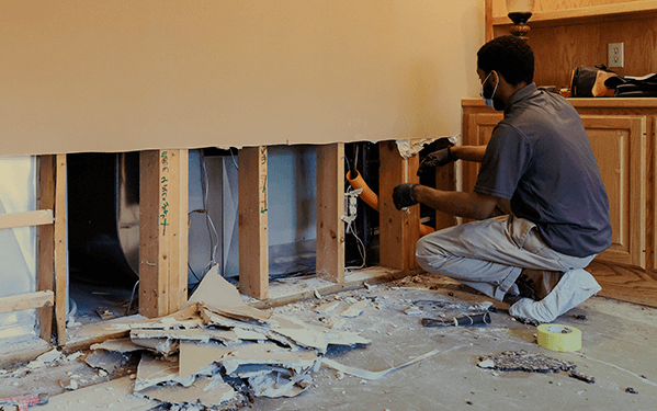 A Green Clean team member working on drywall